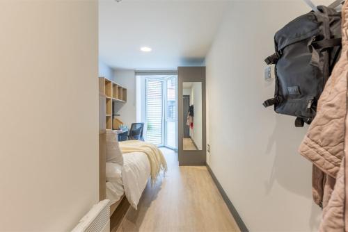 Curraheen Point in Cork في كورك: غرفة نوم مع سرير وحقيبة على الحائط