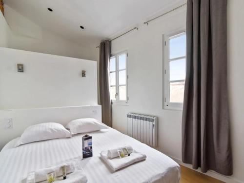 - une chambre blanche avec 2 serviettes sur un lit dans l'établissement Magnifique Appartement Place du Capitole, à Toulouse