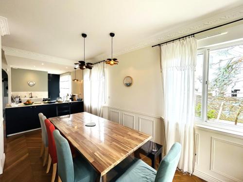 une cuisine et une salle à manger avec une table et des chaises en bois dans l'établissement Maison 5 pièces 6 personnes, plage et port de Larmor à proximité - wifi - YSATIS, à Larmor-Plage