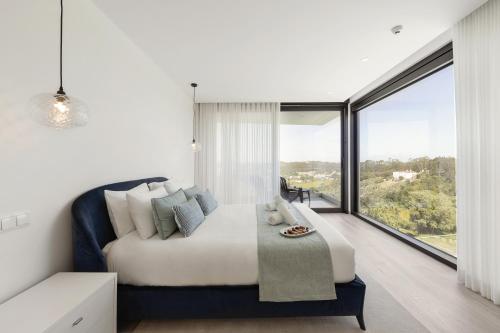 a bedroom with a large bed and a large window at Lux House in Leiria