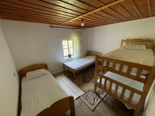 a room with two bunk beds and a window at Motina River Guesthouse in Tropojë
