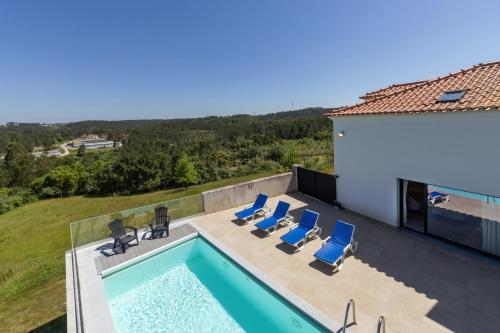 an overhead view of a swimming pool with chairs and a house at Lux House in Leiria
