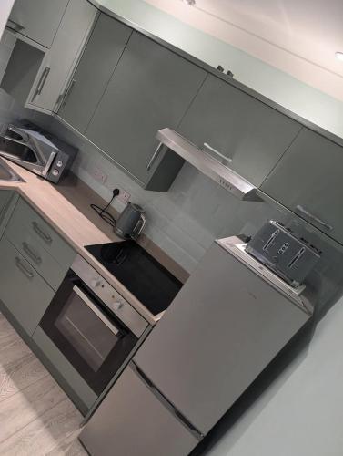 a kitchen with a refrigerator and a stove top oven at Largs seaside retreat in Largs