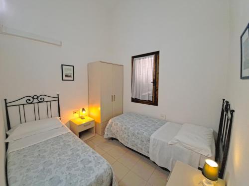 a bedroom with two beds and a table and a mirror at Centro Residenziale Le Canne in San Teodoro
