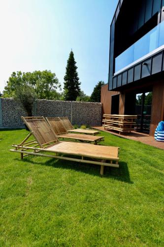 a group of wooden pallets sitting on the grass next to a building at Les Suites in Camiers