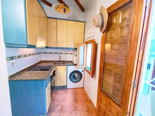 a kitchen with a sink and a washing machine at Casita de Pescadores en La Costera in Villajoyosa