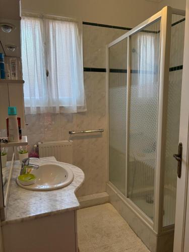 une salle de bain blanche avec une douche et un lavabo dans l'établissement St Cyprien plage grande maison avec piscine, à Saint Cyprien Plage