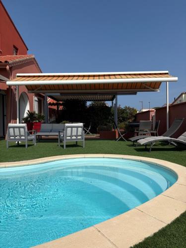 - une piscine dans une cour avec un kiosque dans l'établissement St Cyprien plage grande maison avec piscine, à Saint Cyprien Plage