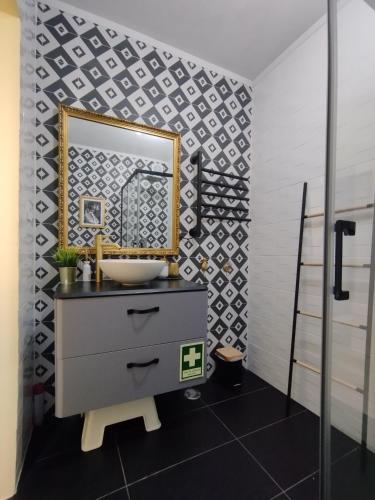 a bathroom with a sink and a mirror on a wall at Sunset House in São Julião