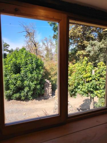 a window in a room with a view of a bush at Casas Viejas de Rauco, casa patrimonial en el campo in Curicó