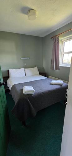 Heather Cottage 3 Bedroom في لويسبورغ: غرفة نوم بها سرير كبير عليه منشفتين