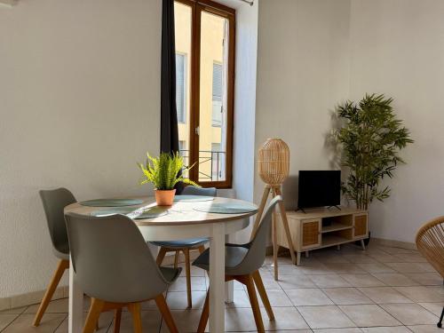 une salle à manger avec une table, des chaises et une télévision dans l'établissement Le Duplex des Arènes,idéalement situé et lumineux, à Nîmes