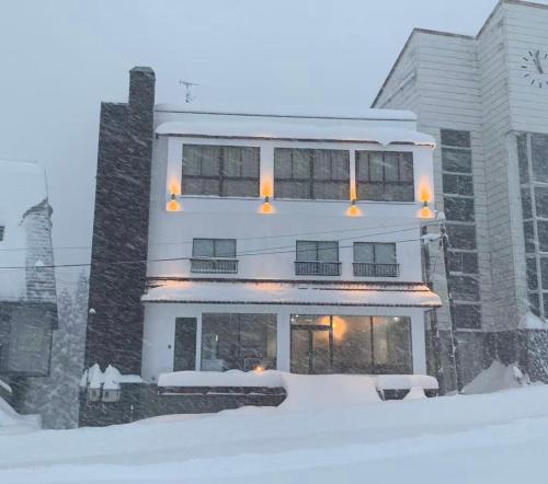 a large building with snow in front of it at Yuzawa YUKITORA 雪虎 in Minami Uonuma