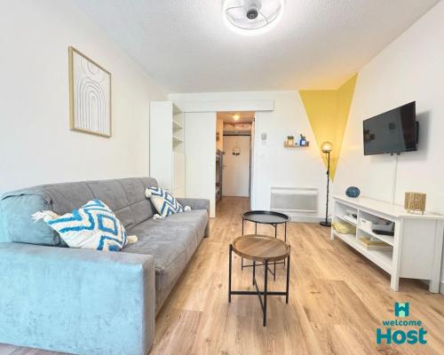 un soggiorno con un divano e un tavolo di Le studio de Lou, 4 couchages Mer & Port a Mauguio