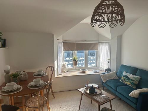 ein Wohnzimmer mit einem blauen Sofa und einem Tisch in der Unterkunft Flat in Woodstock in Woodstock
