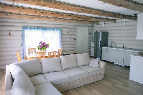 ein Wohnzimmer mit Couch und Küche in der Unterkunft Baurine Puhkemaja in Aseri