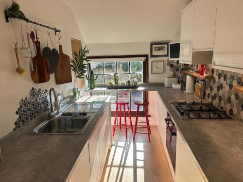 eine Küche mit Spüle und zwei roten Barhockern in der Unterkunft Flat in Woodstock in Woodstock