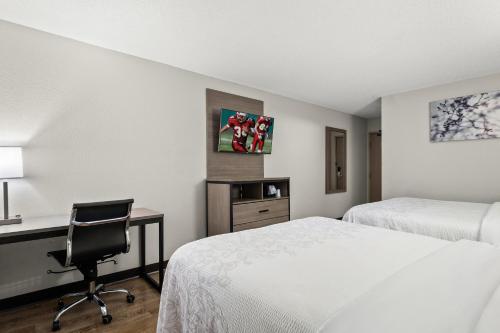 a hotel room with a bed and a desk and a chair at Red Roof PLUS Belleville in Belleville
