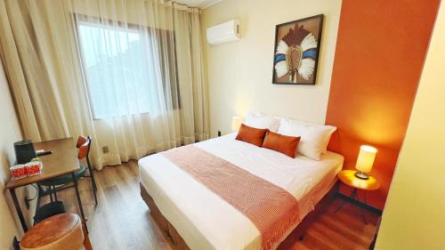 a hotel room with a bed and a window at Cozy House in Rio de Janeiro
