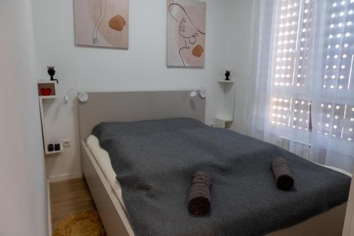 トゥズラにあるApartman Amorの靴下が置かれたベッドのある白い寝室