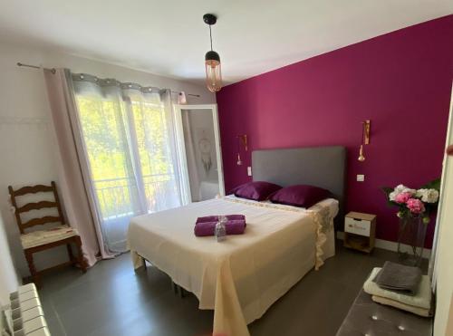 une chambre avec un grand lit aux murs violets dans l'établissement Le Mas de Fabregas - 500 m de la plage, à La Seyne-sur-Mer