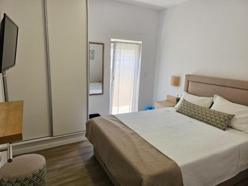 a bedroom with a large bed and a television at Curtido House in Aveiro