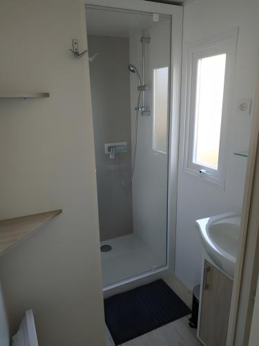 une salle de bain blanche avec une douche et un lavabo dans l'établissement Mobil-home 4 Personnes, Climatisé, à Gastes