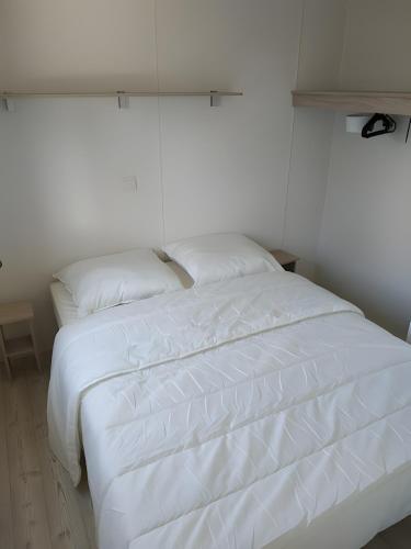 un lit blanc avec deux oreillers dessus dans l'établissement Mobil-home 4 Personnes, Climatisé, à Gastes