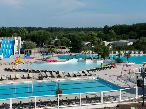 une image d'une grande piscine dans un complexe dans l'établissement Mobil-home 4 Personnes, Climatisé, à Gastes