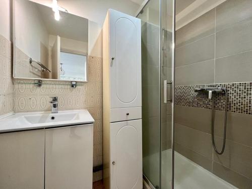 une salle de bain blanche avec une douche et un lavabo dans l'établissement Studio Élégant 3 voyageurs avec Terrasse & Parking Privé, à Saint-Raphaël