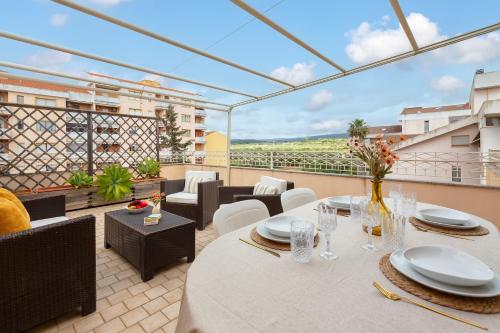 a patio with a table and chairs on a balcony at SARDINIA RE - Libero 22 - Free Parking in Alghero