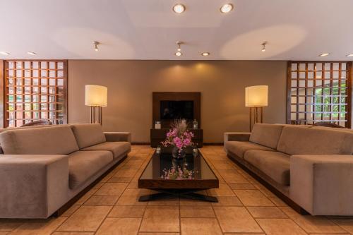 a living room with two couches and a coffee table at Hotel Deville Express Guaira in Guaíra