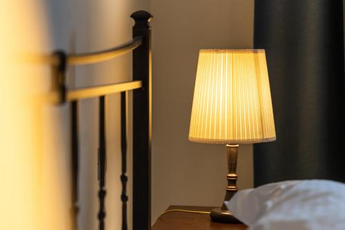 a lamp sitting on a table next to a bed at Ostria Hotel  in Adamas