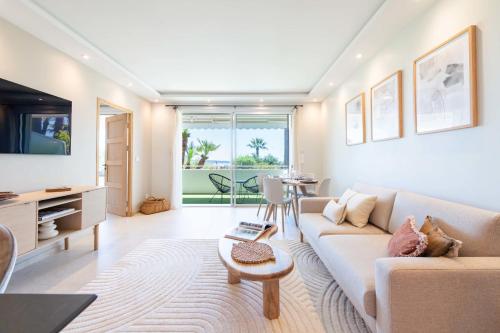 un salon avec un canapé et une table dans l'établissement Cannes Garden-Level 1-Br Apartment Sea View, à Cannes