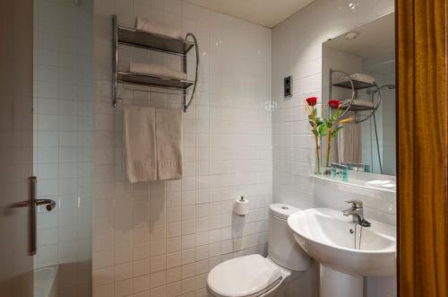 4R Miramar Calafell في كالافيل: حمام ابيض مع مرحاض ومغسلة