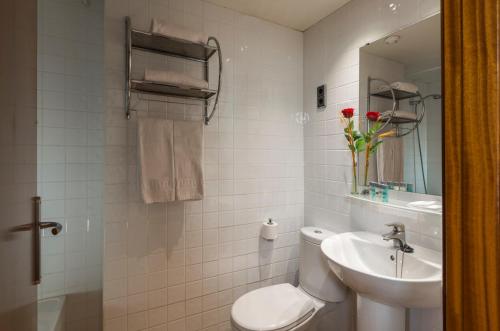 Un baño blanco con inodoro y lavabo. en 4R Miramar Calafell, en Calafell