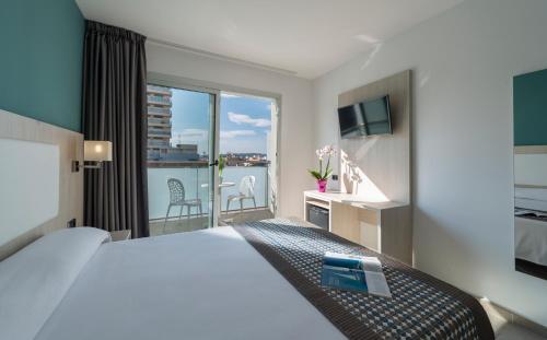 Una habitación de hotel con una cama grande y un balcón. en 4R Miramar Calafell, en Calafell