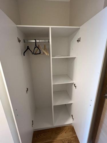 a walk in closet with white shelves at Aisa Street apartments in Pärnu