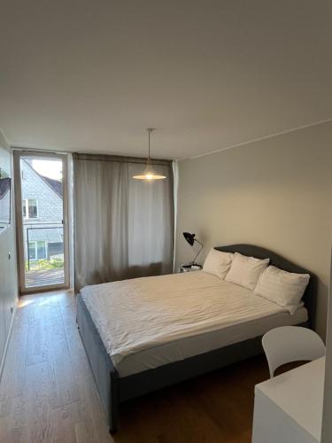 a bedroom with a bed and a large window at Aisa Street apartments in Pärnu