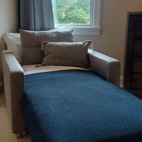 a couch sitting in a room with a window at Dos Brisas by Carolina Mornings in Mars Hill