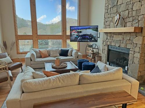 a living room with couches and a stone fireplace at Dos Brisas by Carolina Mornings in Mars Hill