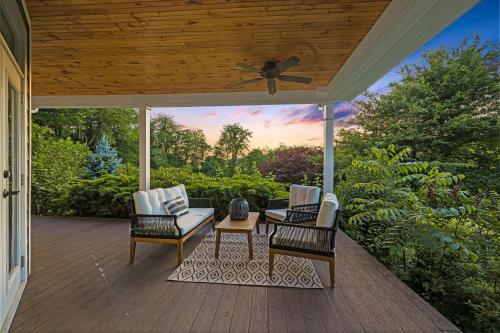 a porch with two chairs and a table and a ceiling at Dos Brisas by Carolina Mornings in Mars Hill