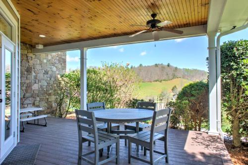 a patio with a table and chairs on a deck at Dos Brisas by Carolina Mornings in Mars Hill