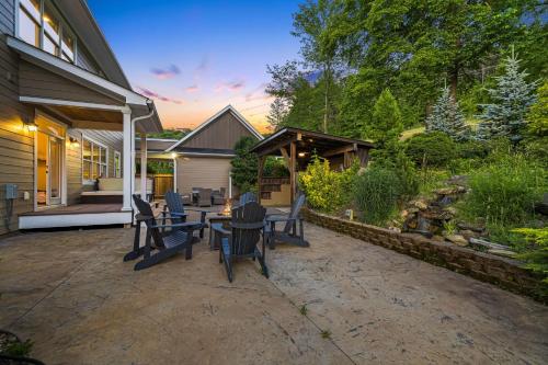 a patio with chairs and a table in a backyard at Dos Brisas by Carolina Mornings in Mars Hill