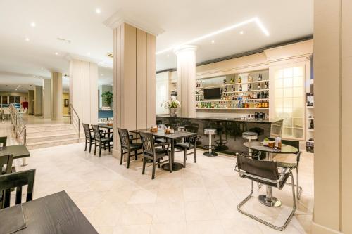 a restaurant with tables and chairs and a bar at Rockefeller by Slaviero Hotéis in Curitiba