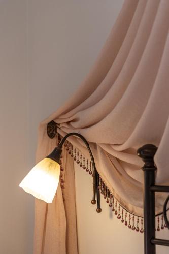 a room with a curtain and a lamp at Ostria Hotel  in Adamas