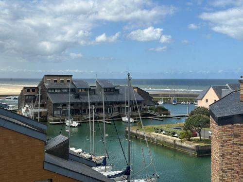 a marina with boats in the water next to buildings at Studio avec balcon vue mer in Deauville