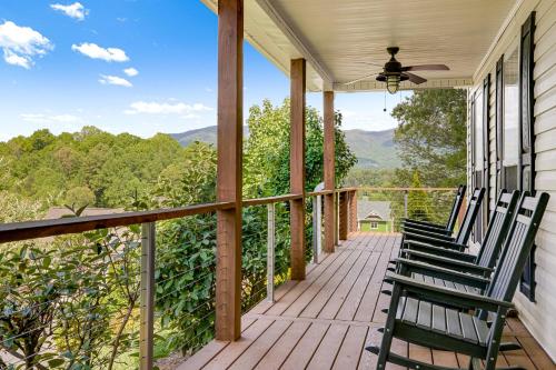 two chairs on a porch with mountains in the background at Lauren Peak by Carolina Mornings in Candler