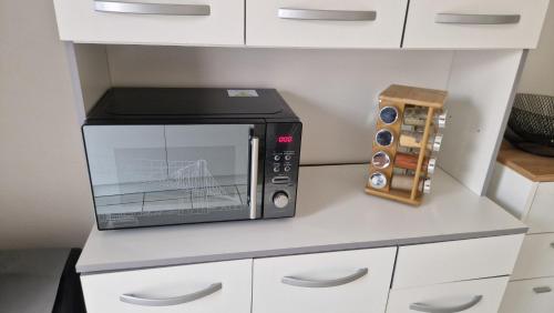 un four micro-ondes installé au-dessus d'un comptoir dans l'établissement Maison 2 chambres à 5 mn du circuit des 24 heures du Mans proche toute commodités, à Arnage