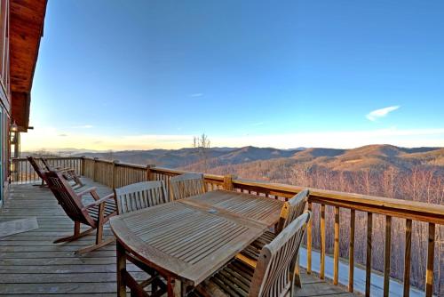 a wooden table and chairs on a deck with a view at Sky High by Carolina Mornings in Swiss